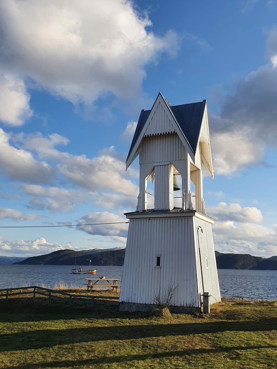 Det hvite klokketårnet på Rødberg ved fjorden