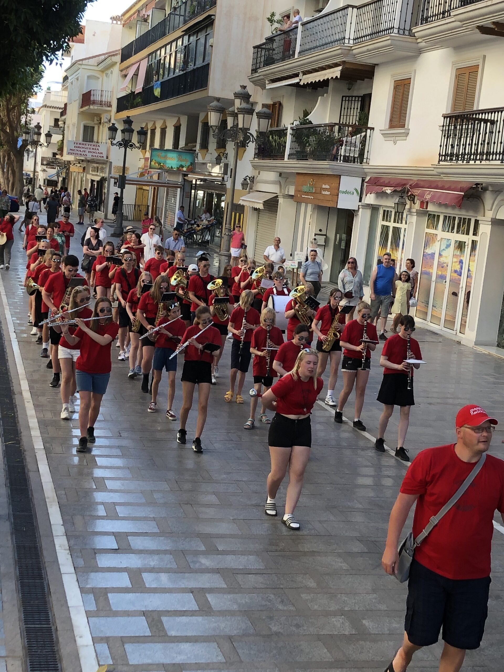 Stadsbygd skolekorps marsjerer gjennom ei gate i Torremolinos