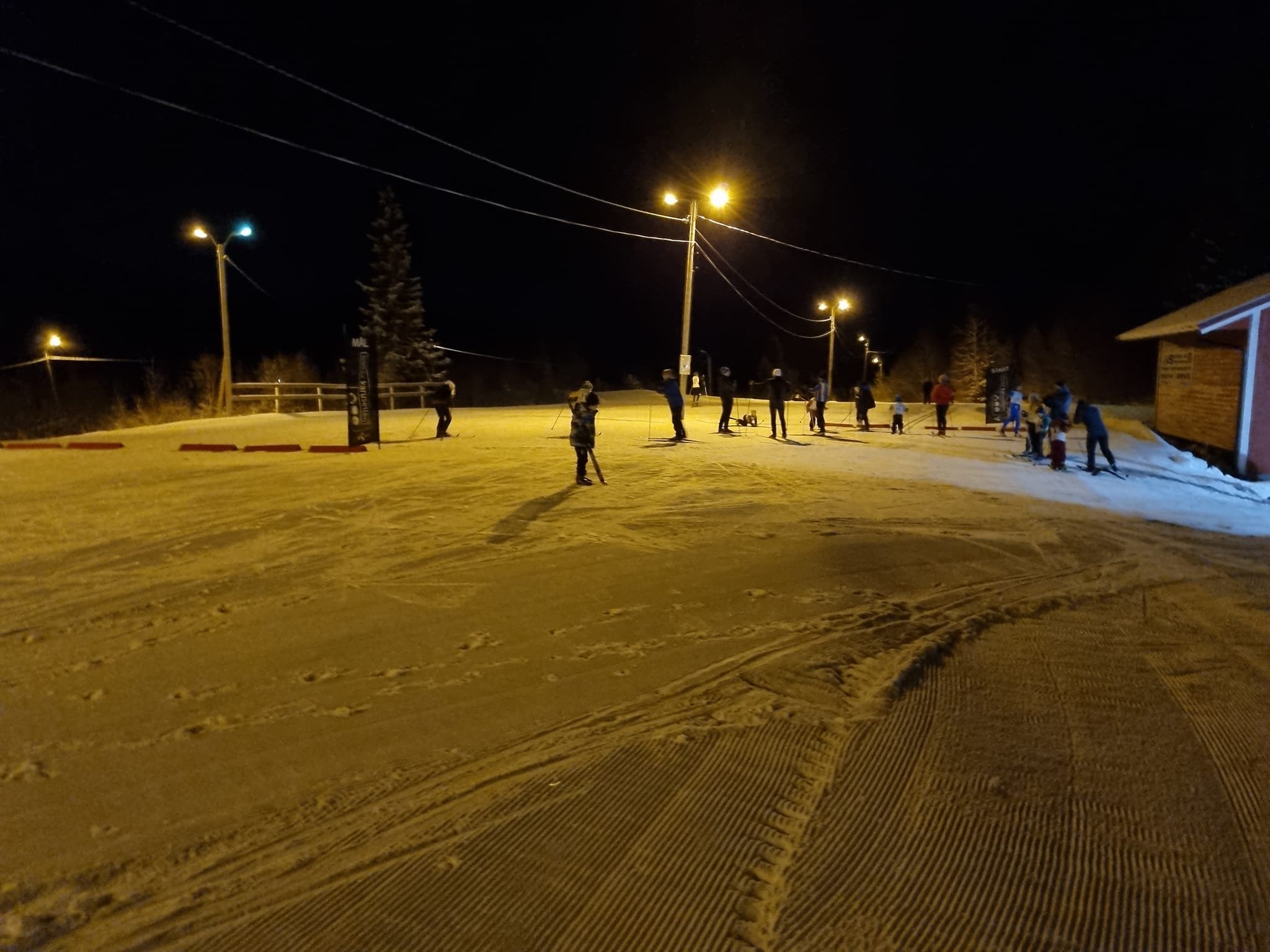 Skiløypa i lysløypa en mørk kveld med skiløpere